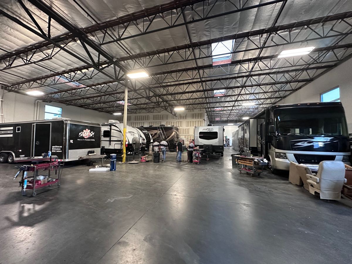 Wide view of Inland Valley RV service bay with multiple RVs being serviced